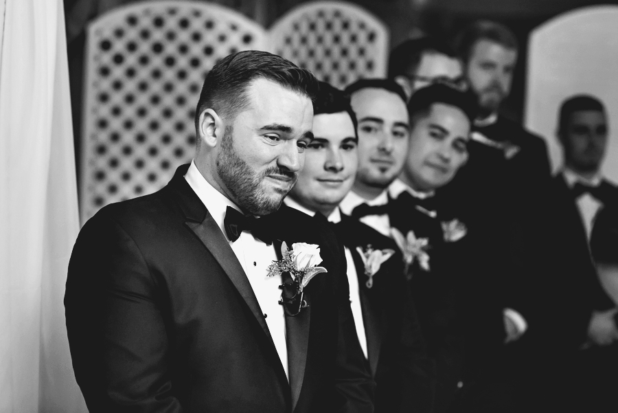 A groom sheds a tear when he sees his bride to be walking down the isle.